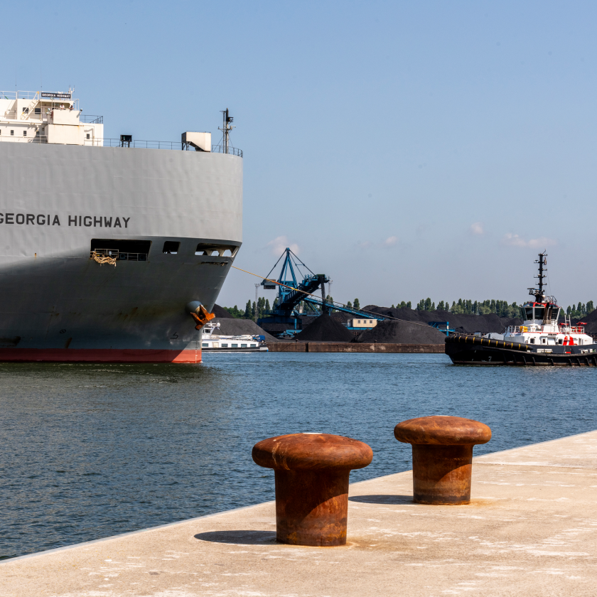 Een medium sleepboot bij vrachtschip 'Georgia Highway'