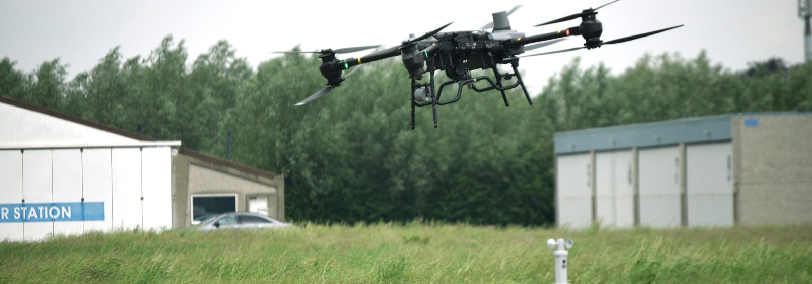 Een DJI FlyCart vliegt op beperkte hoogte over de start- en landingsbaan.